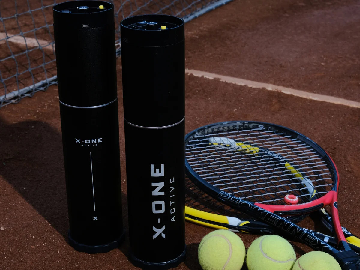 Exploded technical render showing four neon yellow high-bounce padel balls sliding into an elongated matte black pressurized cylinder canister